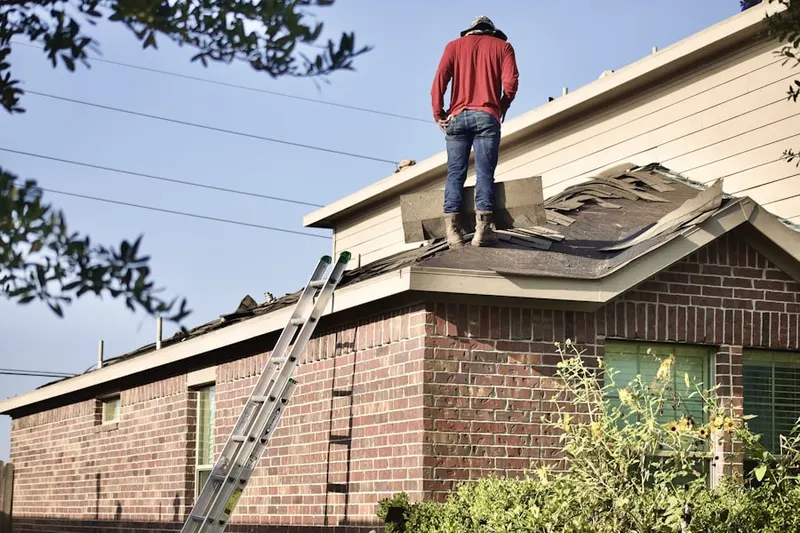 Professional roofer working on a residential roof in Marksboro